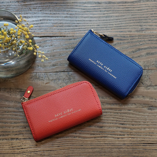 L型ファスナーキーケース エンボスレザー ブルー レッド アークトエディー テーブルに置かれている様子1