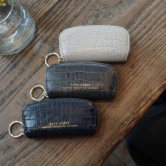 ラウンドファスナー小銭入れ クロコ型押し ネイビー ダークグレー アイボリー アークトエディー テーブルに並べた画像