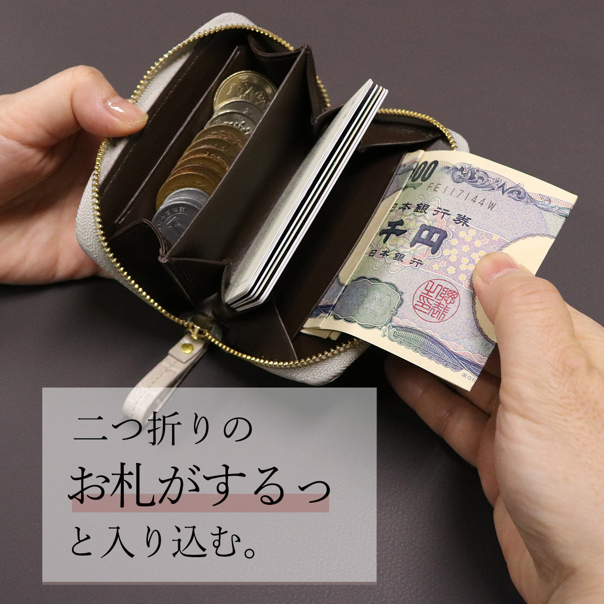 らラウンドファスナーミニ財布 アークトエディー 二つ折りのお札を取り出す様子