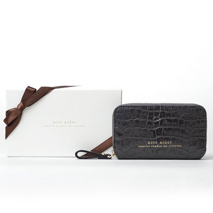 ラウンドファスナー小銭入れパッケージ見本　クロコ型押し　アークトエディー　白い背景に置かれたロゴ入り白箱にブラウンのリボンをかけたパッケージ見本とダークグレーの小銭入れ